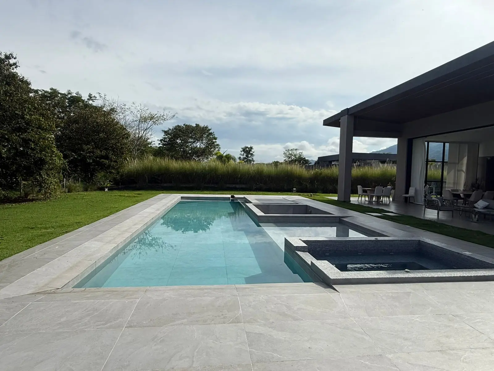 Piscina con jacuzzi y playa húmeda frente a la terraza